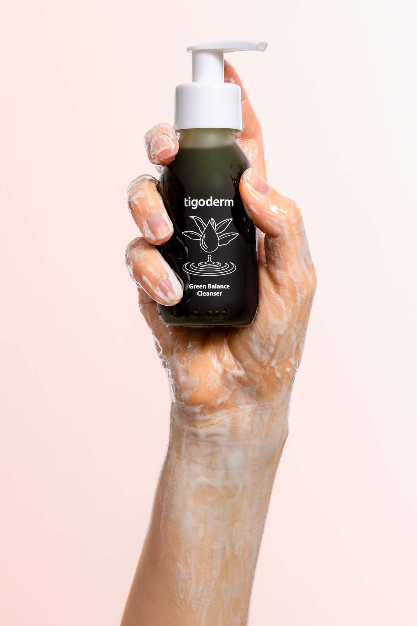 Schaumige Anwendung des tigoderm Green Balance Cleanser Waschgels mit Grüntee in einer Hand.