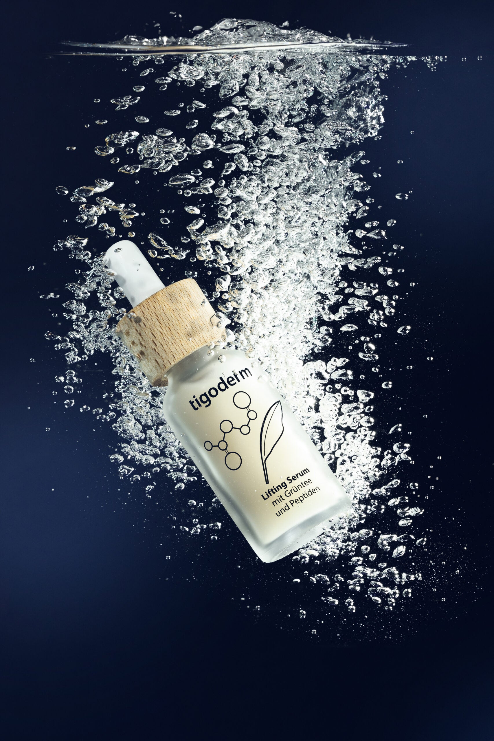 tigoderm Anti-Aging Lifting Serum mit EGCG & Peptiden in Unterwasser-Szene mit Luftblasen vor blauem Hintergrund.